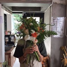 a man holding a bunch of flowers in his hands