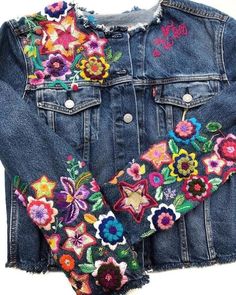 a jean jacket with embroidered flowers on it