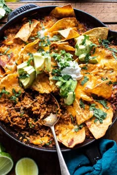 a skillet filled with nachos and tortilla chips