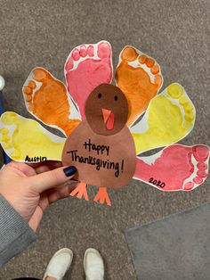 a person holding up a turkey shaped card with the words happy thanksgiving written on it