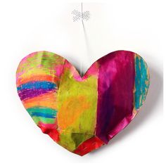 a heart shaped piece of paper that has been made with different colors and shapes on it