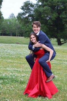 two people are posing for a photo in the grass