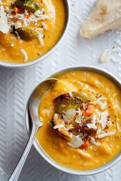 two bowls filled with soup on top of a white table