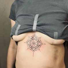 a woman's stomach with a tattoo design on her belly and the bottom part of her abdomen