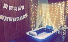 an inflatable hot tub with happy birthday bunting on the wall next to it