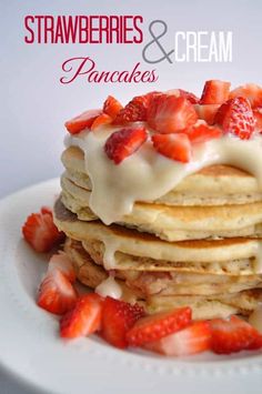 a stack of pancakes topped with strawberries and cream