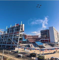 an airplane flying over a stadium during the day