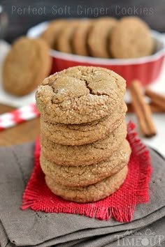 a stack of ginger cookies sitting on top of a red cloth next to cinnamon sticks