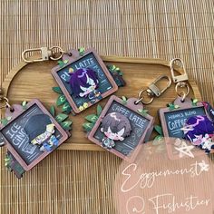 four keychains with pictures of anime characters on them