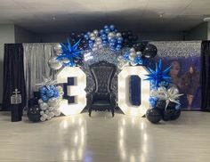 the balloon arch is decorated with blue and silver balloons that spell out the number 30