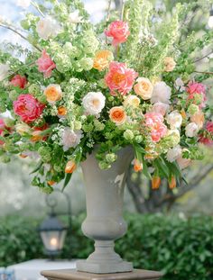 a vase filled with lots of flowers on top of a table