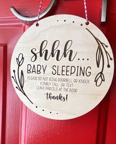 a wooden sign hanging from the side of a red door that says, sha baby sleeping please do not petting doobell or tex leave it at the door