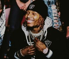 a man with dreadlocks sitting in front of a group of people and smiling