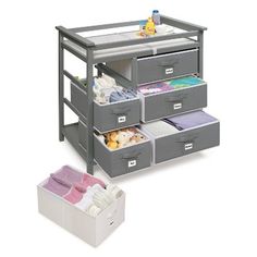 the baby changing table with drawers is open and has several items in it, including blankets