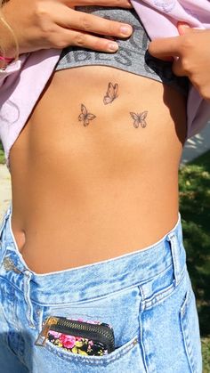 a woman with butterfly tattoos on her stomach