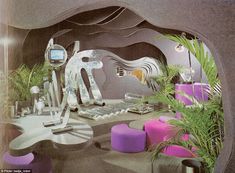 a futuristic office with purple and pink furniture, plants and computer equipment on the desk