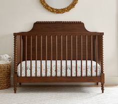 a baby crib in a room with a mirror on the wall