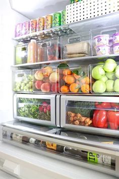 an open refrigerator filled with lots of fresh fruit and veggies in plastic containers