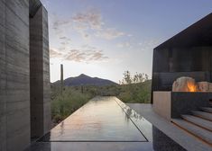 an outdoor fire pit with stairs leading up to it and the mountains in the background