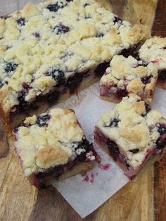 blueberry crumb bars cut into squares on top of a cutting board with one slice taken out