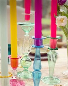 there are many different colored candles on the table