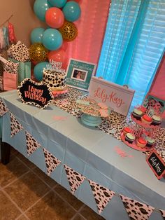 a birthday party table with decorations and balloons