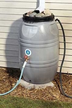 a large gray tank with a hose connected to it sitting in front of a house