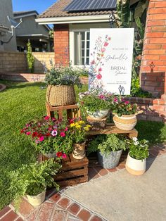 several potted plants are on display in front of a sign that reads, welcome to the garden