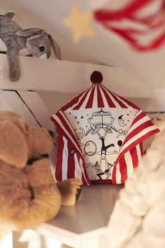 a stuffed animal is sitting on the shelf next to an umbrella and other items that are hanging from the ceiling