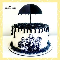 a black and white cake with an umbrella topper on it's icing