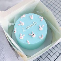 a blue cake decorated with bunnies and the word march in white lettering on it