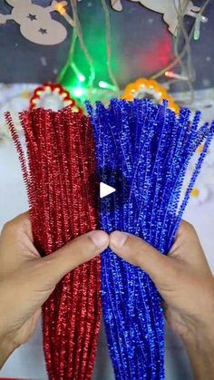 two hands holding red and blue tinseled straws