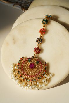 Introducing the Imaari Statement Necklace Set with Maang Tikka and Chandbali Earrings. This exquisite necklace set features multicolor navratan stones with elegant gold plating and high-quality brass filling. The set includes a stunning maang tikka and matching chandbali earrings, making it a perfect style statement for special occasions or parties. The Imaari necklace set is designed to blend tradition with elegance. The intricate design of the maang tikka and the dazzling chandbali earrings co Festive Multicolor 22k Gold Bridal Necklace, Multicolor 22k Gold Temple Jewelry, Multicolor Gold Plated Kundan Necklace With Meenakari, Multicolor Gold Plated Jewelry Sets For Festivals, Multicolor Meenakari Kundan Necklace Gold Plated, Festive Gold Temple Necklace With Multi-stone, Multicolor Gold Plated Jewelry For Diwali, Multicolor Gold-plated Jewelry For Diwali, Multicolor 22k Gold Temple Necklace For Gift