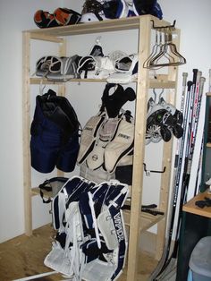 there are many sports gear on the shelves in this room, including backpacks and skis