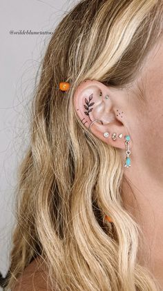 a close up of a person with ear piercings on their ears and behind the ear