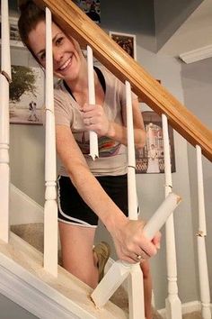 a woman is walking up the stairs with her hand on the bannister rail