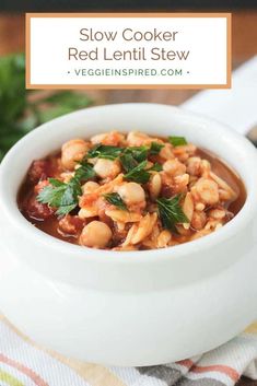 a white bowl filled with beans and garnish on top of a striped cloth