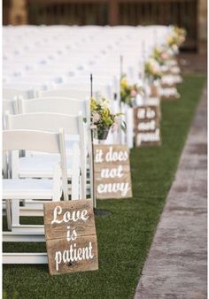 rows of white chairs with wooden signs that say love is patient