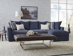 a living room with a blue couch and ottoman