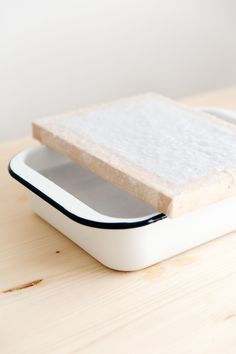 a piece of bread sitting on top of a wooden table next to a cell phone