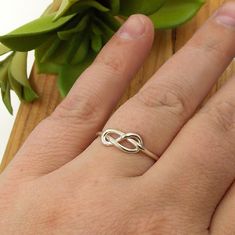 This Infinity Knot Ring is a dainty ring that shows your forever love, friendship, and appreciation for a special someone whether it be a wife, girlfriend, daughter, sister, or best friend. Solid Sterling Silver Infinity Knot Ring Band just over 1mm thick Adjustable Infinity Promise Ring, Adjustable Infinity Ring For Mother's Day, Mother's Day Infinity Adjustable Rings, Personalized Adjustable Infinity Rings, Simple Infinity Jewelry For Anniversary, Infinity Knot Ring, Infinity Knot, Knot Ring, Love Ring