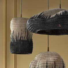 three woven baskets hanging from hooks in a room