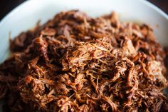 shredded meat in a white bowl on a table