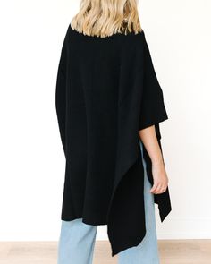 This poncho is oversized with a loose fit, offering a cozy, relaxed silhouette. It has wide, flowing sleeves and an unstructured design that allows for ease of movement. The poncho falls to the upper thigh or mid-hip, providing a comfortable, draped look. The fabric is a soft knit, which suggests warmth and comfort, making it ideal for cooler weather. Available in Black or Camel, the poncho features a high-neck turtleneck or mock-neck style, adding to the cozy and refined look. The edges of the sleeves and body have a ribbed texture, offering subtle detail to the otherwise sleek design.