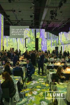 a large room filled with people sitting at tables