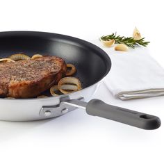 a steak is cooking in a skillet with onions