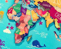 a map of the world with different countries and their name written in colorful letters on it