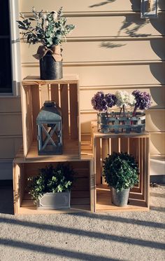 three wooden crates with plants and vases on them