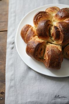 a white plate topped with rolls on top of a table