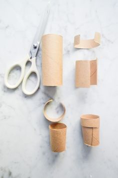 some toilet paper rolls and scissors on a table with other things to cut out from them